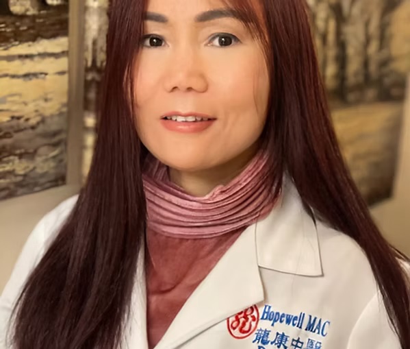 Dr. Long in white clinical coat embroidered with the Hopewell MAC logo