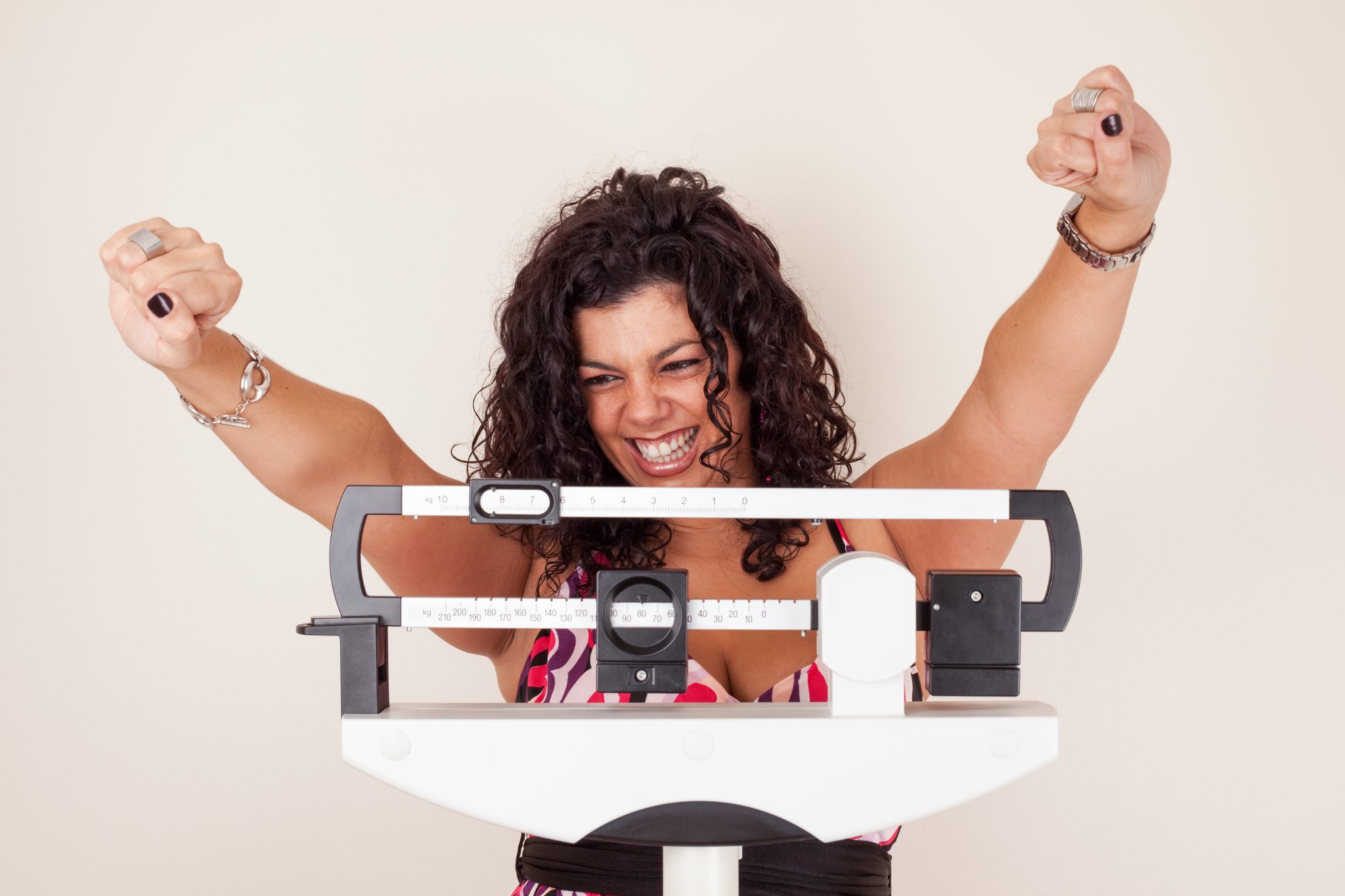 Patient celebrating a weigh-in result with arms raised